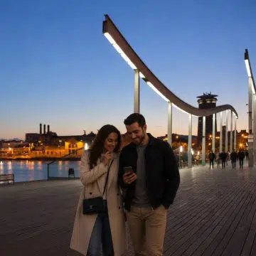 Falista drewniana kładka Rambla de Mar, łącząca dolny odcinek La Rambla z kompleksem Maremagnum po drugiej stronie Port Vell, oferuje panoramiczne widoki na port i otwiera się, umożliwiając łodziom przepływanie przez wody portowe.