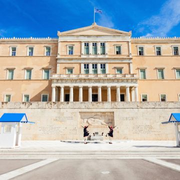 The Tomb of the Unknown Soldier is a symbolic monument where the elite Evzones guards perform their famous ceremonial change of watch. Carved in the 1930s, the cenotaph features a chilling relief of a dying ancient Greek hoplite to honor fallen soldiers throughout history.