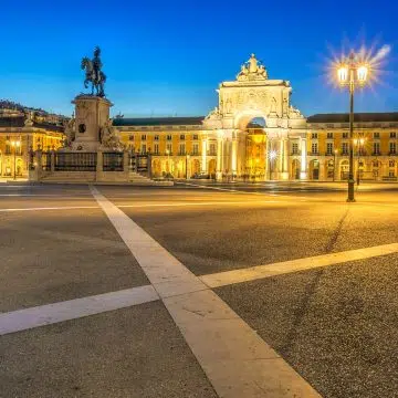 Der Praça do Comércio ist ein prächtiger Platz am Wasser in Lissabon, umrahmt von großen gelben Gebäuden und einem Triumphbogen, der einst als symbolisches Tor zur Stadt für den Seehandel diente.