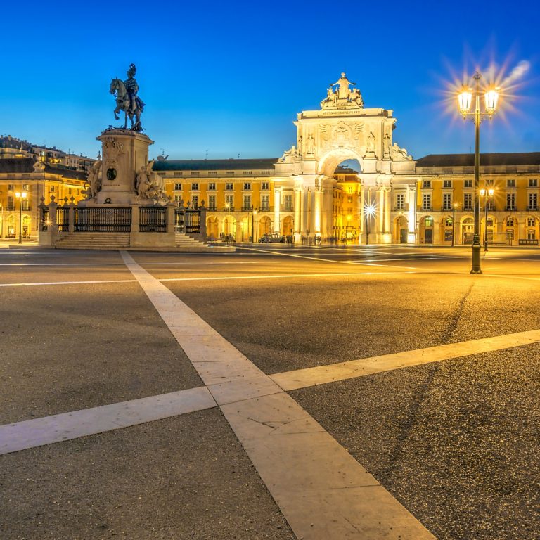 Búsqueda del tesoro y recorrido autoguiado por Lisboa 4 La Praça do Comércio es una magnífica plaza portuaria de Lisboa, enmarcada por grandes edificios amarillos y un arco del triunfo que antaño sirvió de puerta simbólica de entrada a la ciudad para el comercio marítimo.