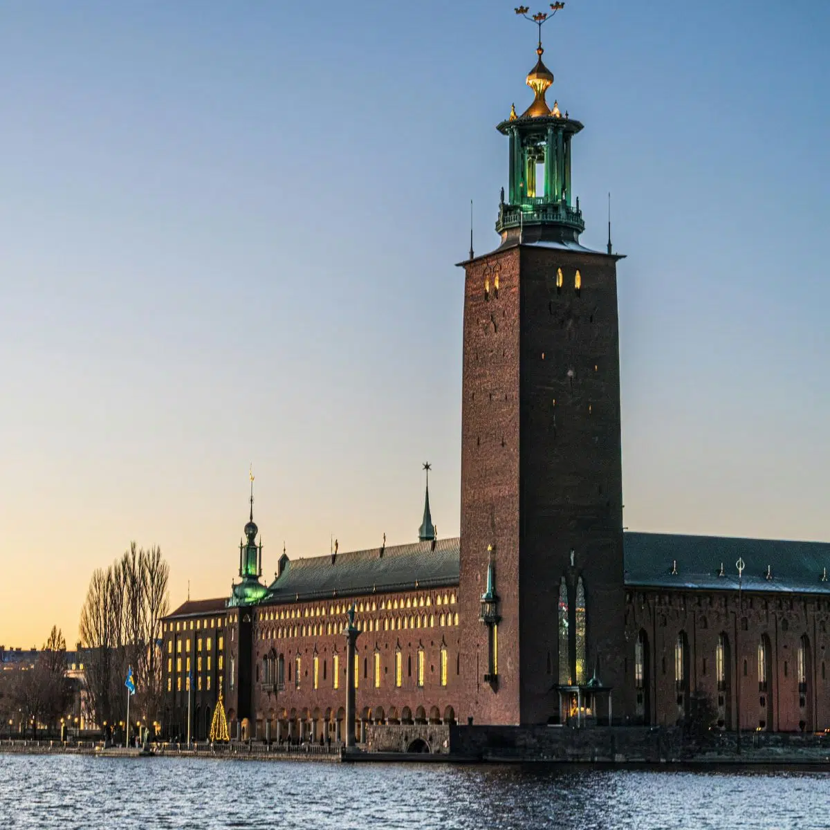 Chasse au trésor et visite libre à Stockholm 5 L'hôtel de ville de Stockholm est un magnifique monument en briques, célèbre pour sa tour flamboyante surmontée de trois couronnes d'or, représentant l'apogée du romantisme national suédois. Il est internationalement connu pour être le lieu du banquet des prix Nobel, avec l'étonnante salle bleue et la scintillante salle dorée, ornée de millions de carreaux de mosaïque.
