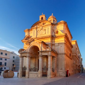 De kerk van St. Catharina van Italië is een prachtige barokke rotonde die in de 16e eeuw werd gebouwd door de Italiaanse ridders van de Johannieterorde. De elegante gevel en indrukwekkende koepel domineren het omringende plein en herbergen prachtige kunstwerken en een titelschilderij van Mattia Preti.