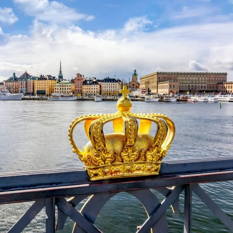 Chasse au trésor et visite libre à Stockholm 2 La couronne dorée du pont Skeppsholmsbron est l'une des icônes les plus photographiées de Stockholm, symbolisant la monarchie suédoise et l'héritage royal de la ville. Perchée élégamment sur la rambarde du pont, elle offre une vue parfaitement cadrée sur le palais royal de l'autre côté de l'eau, ce qui en fait un lieu de prédilection pour capturer l'essence de la capitale.