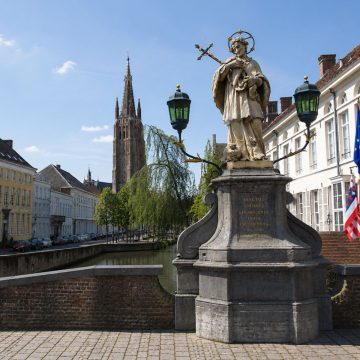 Nommé en l'honneur de saint Jean Népomucène, ce pont de pierre pittoresque offre une vue digne d'une carte postale sur les canaux historiques de Bruges, où les saules pleureurs effleurent délicatement l'eau, lisse comme un miroir.