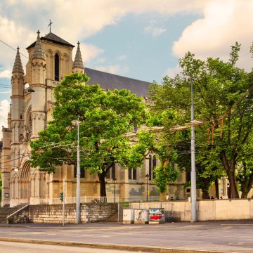 A Basílica de Notre-Dame de Genebra é a principal igreja católica da cidade, apresentando um design neoclássico deslumbrante que contrasta elegantemente com a história da Reforma da cidade. Construída em meados do século XIX, é célebre pelos seus notáveis vitrais e pela sua atmosfera pacífica e espiritual, localizada perto da movimentada estação ferroviária principal.