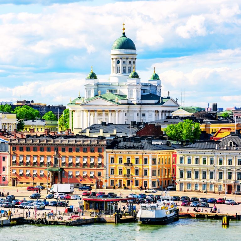 Speurtocht en rondleiding op eigen houtje in Helsinki 4 De kathedraal van Helsinki is een majestueus neoklassiek monument met een grootse witte gevel en iconische groene koepels die een monumentale aanwezigheid creëren en uitkijken over het Senaatsplein van de stad.
