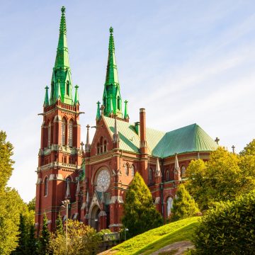 De Sint-Janskerk is een majestueus monument in gotische stijl met twee rode bakstenen torenspitsen en grote decoratieve gevels in de wijk Ullanlinna in Helsinki.