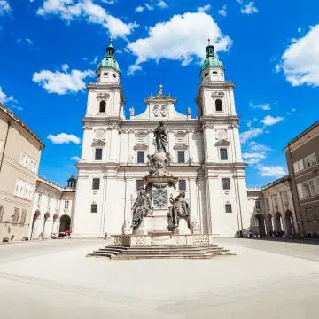 De kathedraal van Salzburg is een prachtig barok meesterwerk uit de 17e eeuw dat bekend staat om zijn opvallende koperen koepel, sierlijke marmeren gevel en zijn historische betekenis als de plek waar Mozart werd gedoopt.