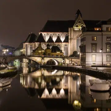 De Sint-Michielsbrug en -kerk zijn majestueuze architecturale monumenten waar een grote stenen brug en gotische torenspitsen een monumentaal panorama vormen over de schilderachtige grachten van Gent.