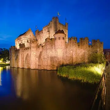 Gravensteen is een majestueus middeleeuws fort waar een grote stenen slotgracht en imposante kantelen een monumentaal oriëntatiepunt vormen in het historische hart van Gent.
