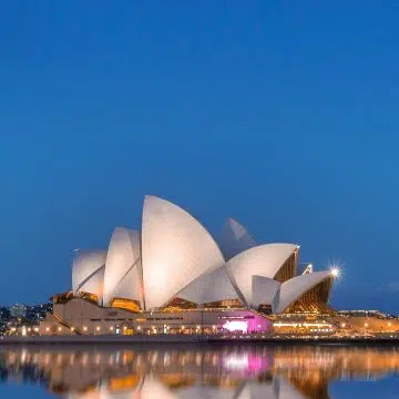 Opera w Sydney to majestatyczny, nowoczesny punkt orientacyjny, w którym wielki dach przypominający żagiel i białe ceramiczne płytki tworzą monumentalne arcydzieło architektury na skraju lśniącego portu w Sydney.