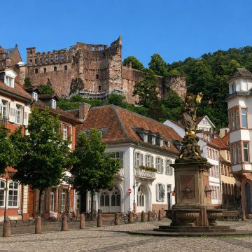 Il Kornmarkt è un'incantevole piazza del centro storico di Heidelberg, incentrata sulla fontana della Madonna del XVIII secolo e che offre una delle viste più iconiche delle rovine del castello che svettano in alto. Originariamente un vivace mercato del grano, questo elegante spazio è incorniciato da edifici storici e funge da tranquilla porta d'ingresso per la salita in funicolare al maestoso Schloss Heidelberg.
