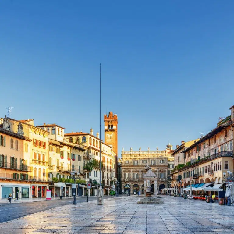 Caça ao tesouro e visita autoguiada a Verona 4 A Piazza delle Erbe é uma praça vibrante construída sobre o antigo Fórum Romano, rodeada por palácios históricos e pela icónica fonte da Madonna Verona que, em conjunto, definem a vida cívica da cidade.