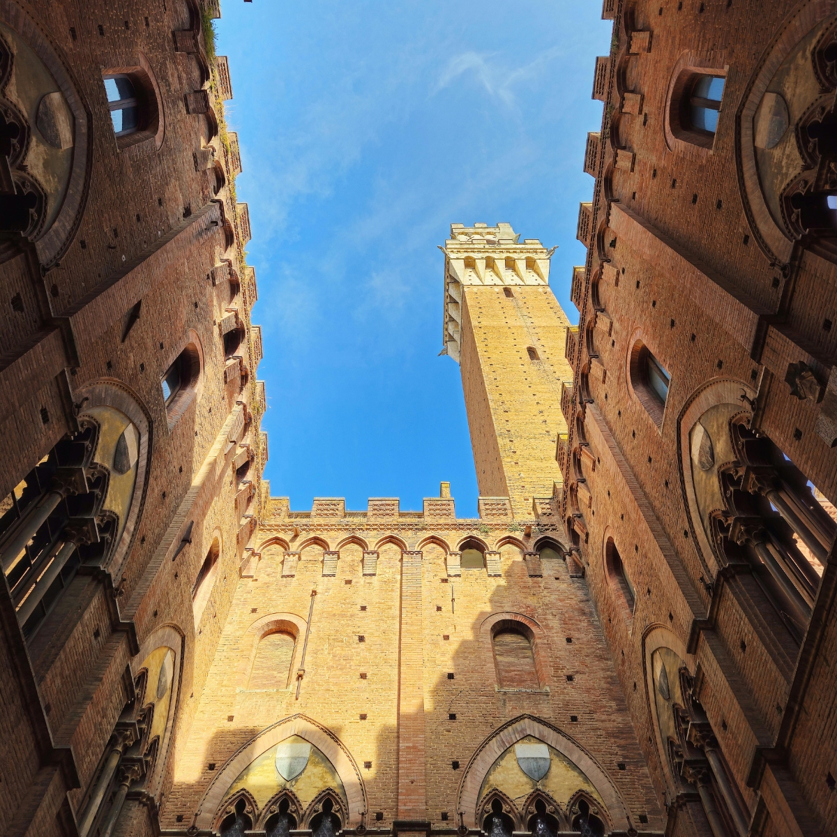 Siena Scavenger Hunt and Self-Guided Tour 6 Torre del Mangia is a majestic medieval tower where a grand slender shaft and sweeping views of the Tuscan landscape create a monumental landmark overlooking the Piazza del Campo.