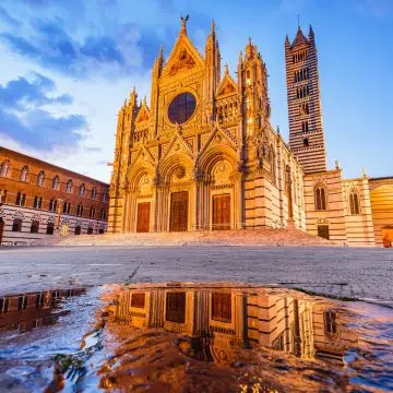 Siena Cathedral is a majestic Gothic landmark where a grand black-and-white striped facade and intricate marble floor mosaics create a monumental masterpiece in the heart of Tuscany.