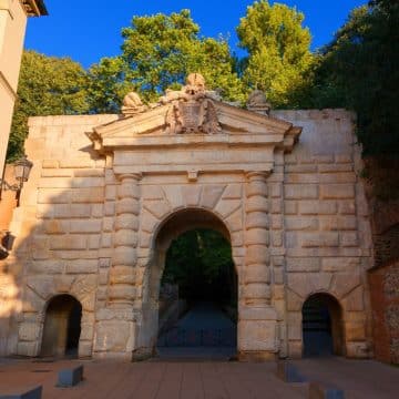 La Puerta de las Granadas, à Grenade, est une imposante porte de style Renaissance dont les trois arches en pierre forment une entrée majestueuse vers les sentiers boisés menant à l'Alhambra.