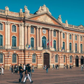 The Capitole de Toulouse is a majestic Neoclassical landmark where a grand limestone and pink brick facade and historic ceremonial halls create a monumental architectural heart for the city's government.