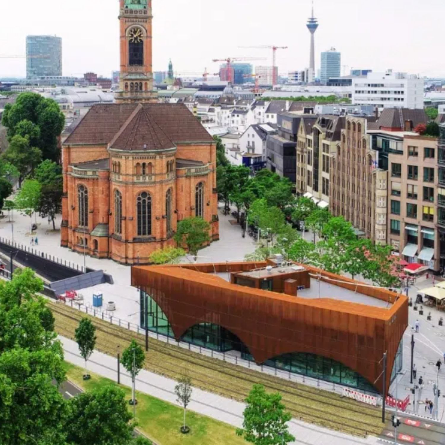 Caça ao tesouro e visita autoguiada a Düsseldorf 4 Framed by the striking neo-Gothic Johanneskirche, Martin-Luther-Platz serves as a stately open square marked by grand historic monuments and landscaped walkways.