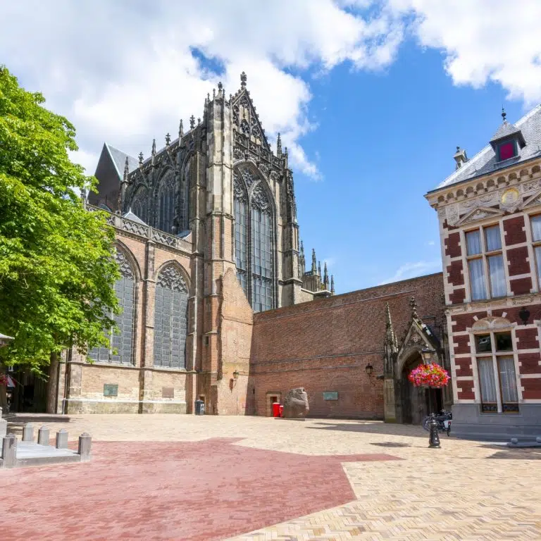 Juego de pistas y visita autoguiada por Utrecht 3 La Catedral de San Martín, también conocida como la Iglesia Dom, es un impresionante monumento gótico que fue en su día la iglesia más grande de los Países Bajos y el corazón del poderoso Obispado de Utrecht. La catedral es famosa sobre todo por su desaparecida nave central, que se derrumbó durante un catastrófico tornado en 1674, separando para siempre la iglesia de su emblemática Torre Dom y creando el espacio abierto que hoy se conoce como Plaza Dom.
