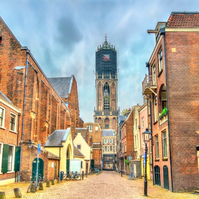 Juego de pistas y recorrido autoguiado por Utrecht 2 La Torre Dom es el campanario más alto de los Países Bajos, una obra maestra gótica de 112 metros que domina el horizonte de Utrecht desde el siglo XIV. Originalmente unida a la Catedral de San Martín, se convirtió en una estructura independiente después de que una fuerte tormenta en 1674 derrumbara la nave de la catedral, dejando la torre como un símbolo resistente del patrimonio medieval de la ciudad.
