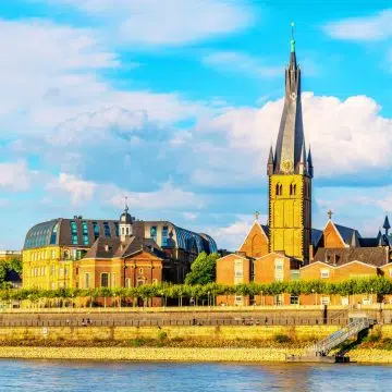 De St. Lambertuskerk is een majestueus gotisch oriëntatiepunt waar een grote gedraaide spits en oude bakstenen architectuur een monumentaal silhouet vormen langs de skyline van Düsseldorf.
