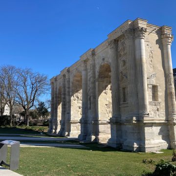 The Porte de Mars is a monumental 3rd-century Roman arch that stands as the largest of its kind in the Roman world, featuring three massive archways decorated with intricate reliefs depicting the legend of Romulus and Remus.