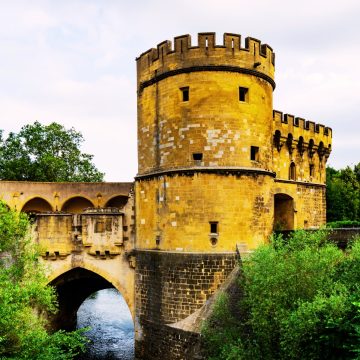 La Porte des Allemands est une majestueuse porte fortifiée et un pont qui enjambe la Seille, où deux tours crénelées se dressent comme une puissante forteresse médiévale de Metz.