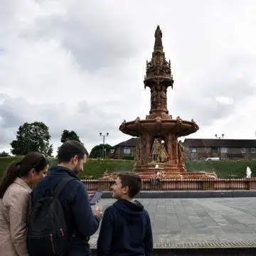 The Doulton Fountain in Glasgow is an elaborate Victorian landmark adorned with detailed sculptures, celebrating the people and cultures of the former British Empire through its richly decorated design.