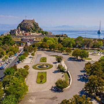Der Spianada-Platz auf Korfu ist ein weitläufiger und eleganter öffentlicher Platz im Herzen der Stadt Korfu, umgeben von historischer Architektur, grünen Gärten und Zeugnissen des venezianischen und britischen Erbes der Insel.