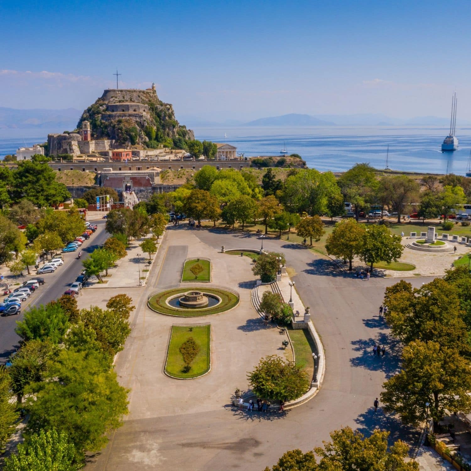 Schatzsuche auf Korfu und Tour auf eigene Faust 5 Der Spianada-Platz auf Korfu ist ein weitläufiger und eleganter öffentlicher Platz im Herzen der Stadt Korfu, umgeben von historischer Architektur, grünen Gärten und Zeugnissen des venezianischen und britischen Erbes der Insel.