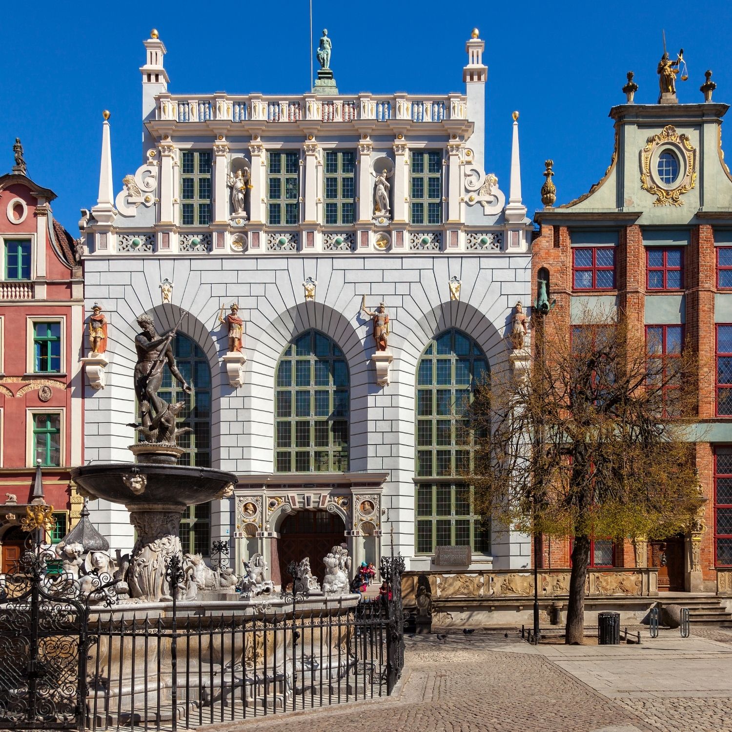 Búsqueda del tesoro y visita autoguiada por Gdansk 3 Este opulento edificio emblemático de estilo gótico-renacentista, que en su día fue el salón de reuniones exclusivo de la élite mercantil y la nobleza hanseática de Gdańsk, deslumbra por su legendaria historia y sus imponentes interiores repletos de obras de arte.