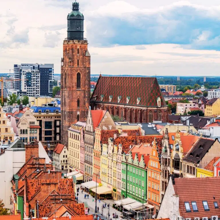 Speurtocht en rondleiding op eigen houtje door Wrocław 5 De St. Elizabethkerk is een torenhoog gotisch monument dat bekend staat om zijn indrukwekkende bakstenen architectuur en een 91 meter hoge torenspits die een adembenemend uitzicht biedt over het historische centrum. Het omliggende Oude Stad Marktplein is een van de grootste stedelijke pleinen van Europa, omzoomd met kleurrijke herenhuizen en levendige kraampjes die de middeleeuwse charme en levendige sfeer van de stad benadrukken.