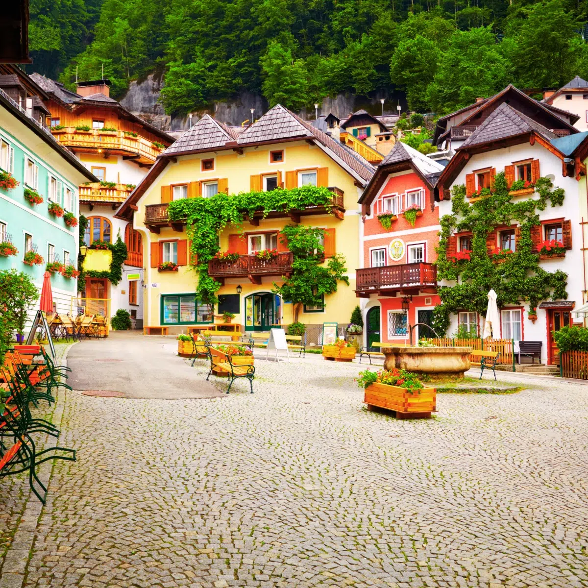 Schnitzeljagd und selbstgeführte Tour durch Hallstatt 6 Der Marktplatz von Hallstatt ist das pulsierende Herz des UNESCO-geschützten Dorfes, umgeben von malerischen, pastellfarbenen Häusern und traditionellen Alpenbalkonen, die eine wahrhaft legendäre europäische Atmosphäre schaffen.