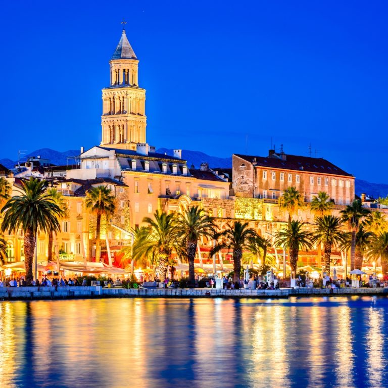 Búsqueda del tesoro dividida y visita autoguiada 3 El paseo de la Riva es un vibrante paseo marítimo bordeado de palmeras y cafés, que hace las veces de salón de la ciudad enclavado junto a las antiguas murallas del Palacio de Diocleciano.