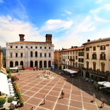 A Piazza Vecchia é uma majestosa praça renascentista onde a fonte histórica e os marcos medievais criam o coração elegante e intemporal da Cidade Alta de Bérgamo.