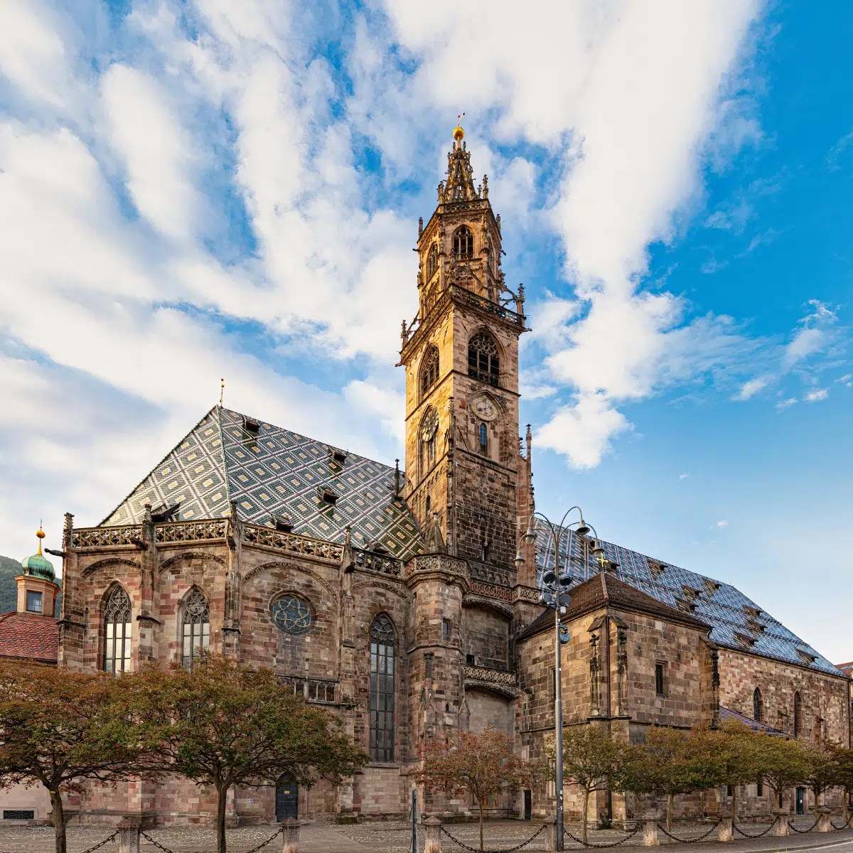 Bolzano Scavenger Hunt and Self-Guided Tour 6 The Bolzano Cathedral is a stunning Gothic and Romanesque masterpiece famous for its intricately patterned polychrome tiled roof and its elegant, open-work sandstone spire.