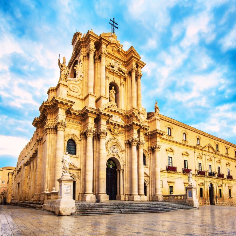 Búsqueda del tesoro y recorrido autoguiado por Siracusa 4 La Catedral de Siracusa es una impresionante maravilla arquitectónica que incorpora de forma única las antiguas columnas dóricas de un templo griego a su grandiosa fachada barroca siciliana.