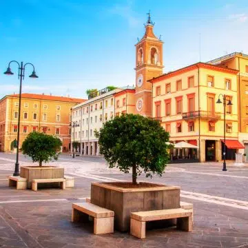 Una vista vivace di Piazza Tre Martiri, una piazza storica nel cuore di Rimini costruita sull'antico foro romano e intitolata a tre martiri della resistenza locale.