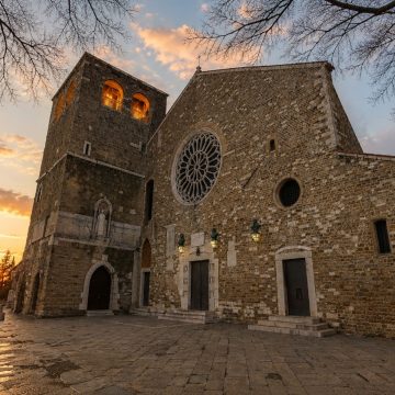 Dominating the city's historic hilltop, the Cattedrale di San Giusto Martire is a 14th-century cathedral renowned for its striking rose window, Roman archaeological foundations, and exquisite Byzantine-style mosaics.