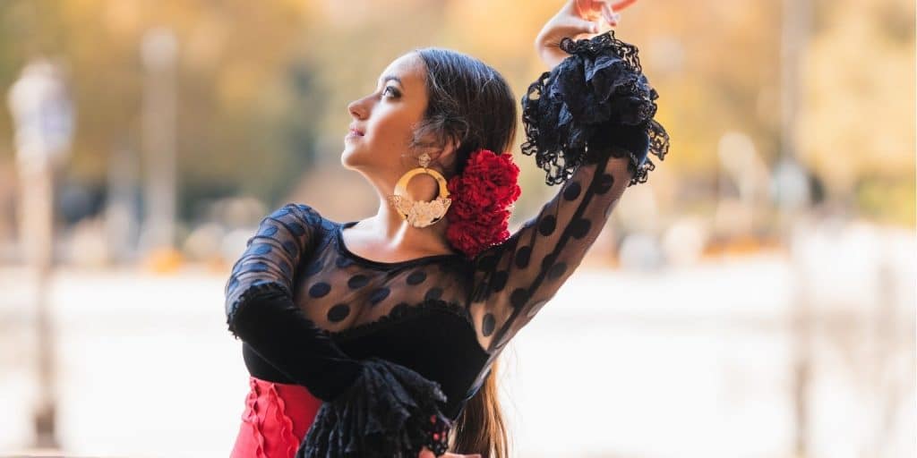 Granada erleben: Die besten Sehenswürdigkeiten, Essen und Tagesausflüge 5 eine Frau in einem schwarzen Kleid mit einer roten Blume im Haar