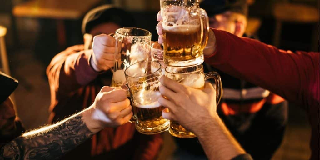 "Najlepszy przewodnik turystyczny po Hamburgu: Zwiedzanie, jednodniowe wycieczki i nie tylko" 3 grupa ludzi trzymających kufle piwa
