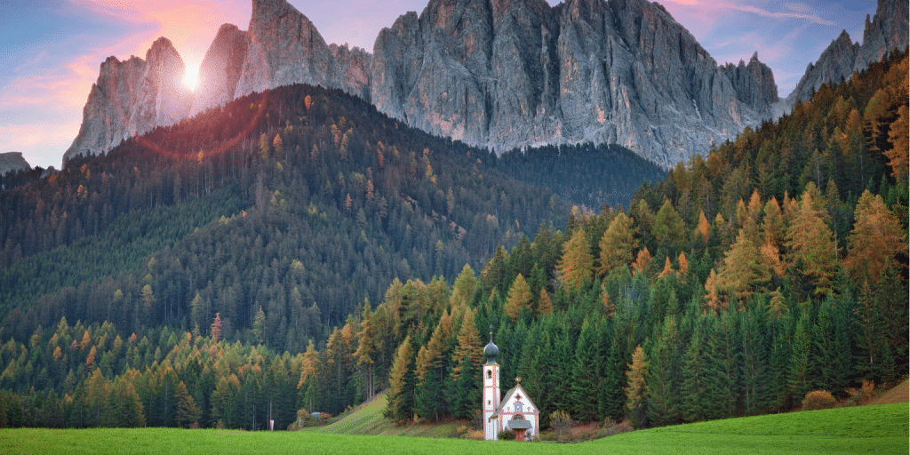 Bolzano ontdekken: Topactiviteiten die je niet mag missen 3 een kerk in een veld met bomen en bergen op de achtergrond