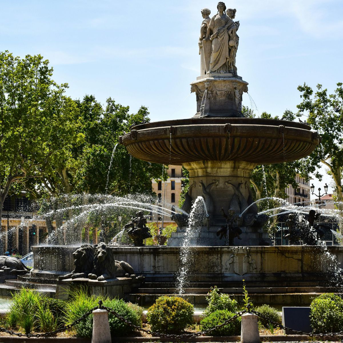 Juego de pistas y recorrido autoguiado por Aix-en-Provence 6 La elegante Fontaine de la Rotonde es la gran fuente emblemática de Aix-en-Provence, con impresionantes esculturas, cascadas de agua y un animado ambiente a las puertas del centro histórico de la ciudad.