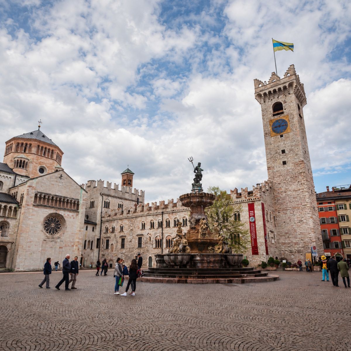 Zabawa w poszukiwanie skarbów i samodzielna wycieczka po Trydencie 4 Piazza del Duomo to eleganckie serce Trydentu, otoczone zabytkowymi pałacami, kawiarniami i kultową katedrą w Trydencie, z piękną fontanną Neptuna tworzącą żywą i malowniczą atmosferę pod alpejską panoramą.