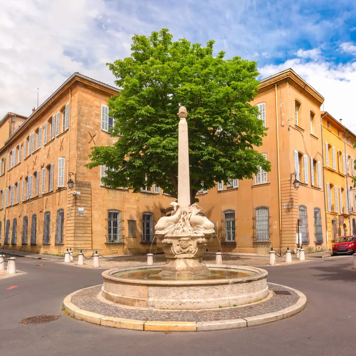 Juego de pistas y visita autoguiada por Aix-en-Provence 2 Enclavada en el corazón del elegante barrio de Mazarin, esta pintoresca plaza del siglo XVII cuenta con una impresionante fuente barroca adornada con cuatro delfines esculpidos chorreando agua, lo que la convierte en una cautivadora parada en su exploración arquitectónica de Aix-en-Provence.