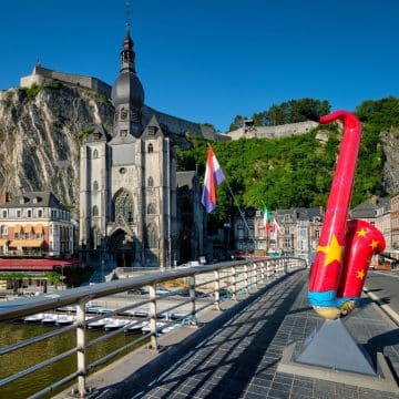 The Collegiate Church of Notre-Dame de Dinant is a striking Gothic landmark, instantly recognizable by its distinctive onion-shaped bell tower and dramatic setting beneath the towering cliffs of the Citadel.
