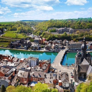 The Pont Charles de Gaulle in Dinant spans the River Meuse beneath the dramatic Citadel, with its colourful saxophone sculptures celebrating the city’s unique musical heritage.