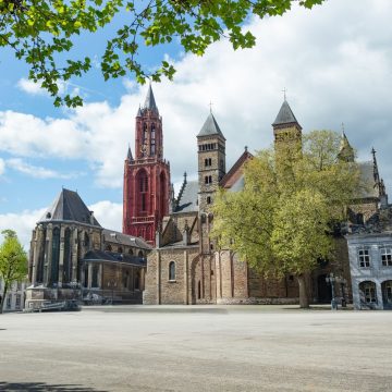 Framed by the monumental duo of the Romanesque Basilica of Saint Servatius and the red-towered Gothic Church of Saint John, the grand, tree-shaded Vrijthof square pulses with lively terrace cafés and centuries of pilgrimage and festive cultural traditions.