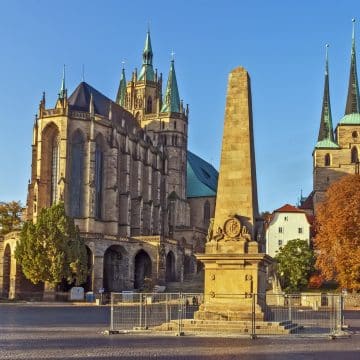 La Domplatz d'Erfurt est une grande place historique bordée de bâtiments colorés et dominée par l'impressionnante cathédrale d'Erfurt et l'église Saint-Sévère, qui s'élèvent de manière spectaculaire au-dessus d'elle.