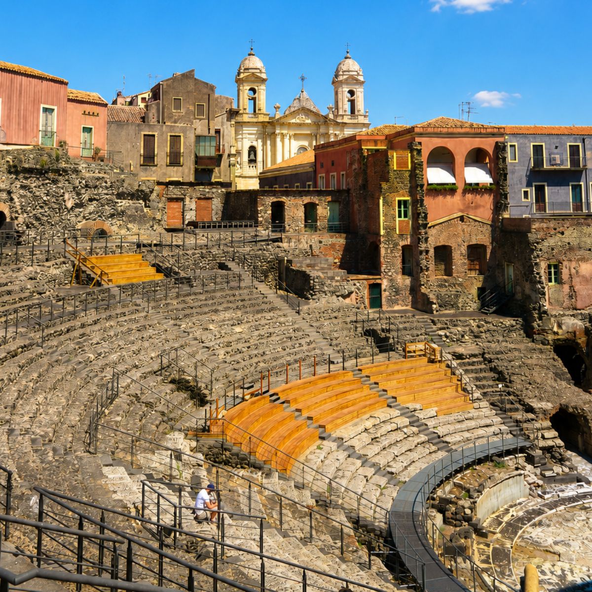 Speurtocht en rondleiding op eigen houtje in Catania 6 Het Romeinse amfitheater is een majestueuze oude bezienswaardigheid waar een grote ondergrondse ruïne van vulkanisch gesteente en wit marmeren zitplaatsen een monumentaal venster creëert op het keizerlijke Romeinse verleden van Catania.